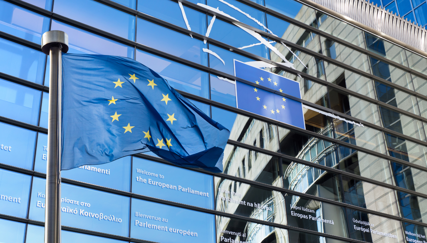 a decorative element: In the foreground, the European Union flag flies from a flagpole. In the background, the modern, glass facade of the European Parliament building