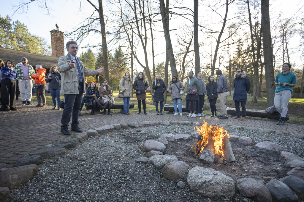 A group of people standing by the fire.