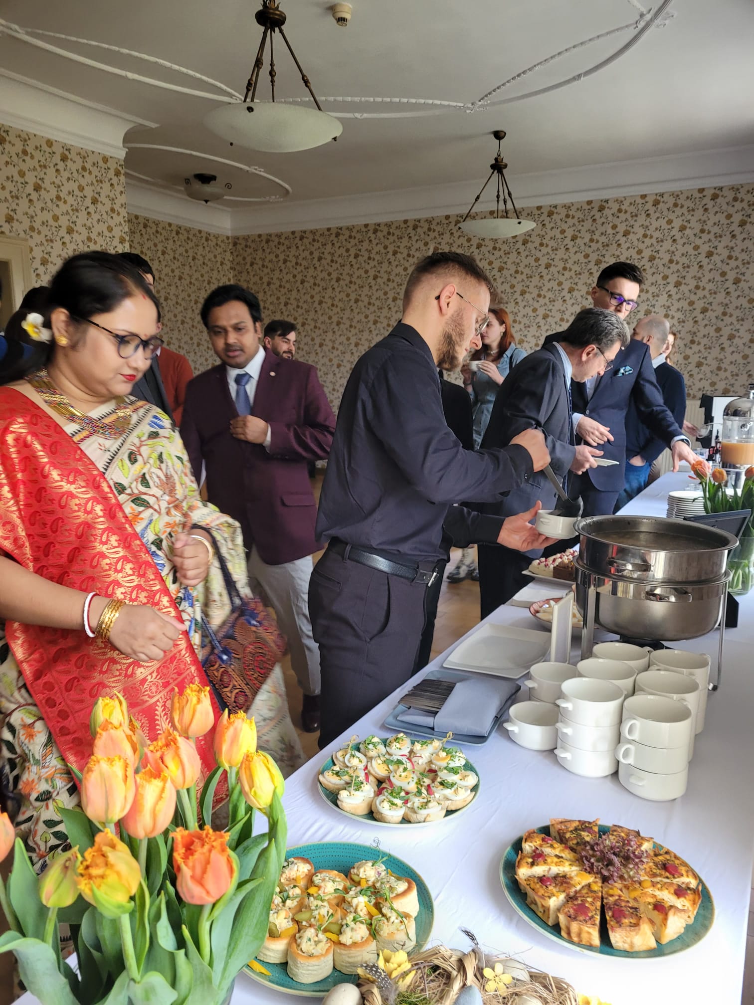 A group of people talking and eating.
