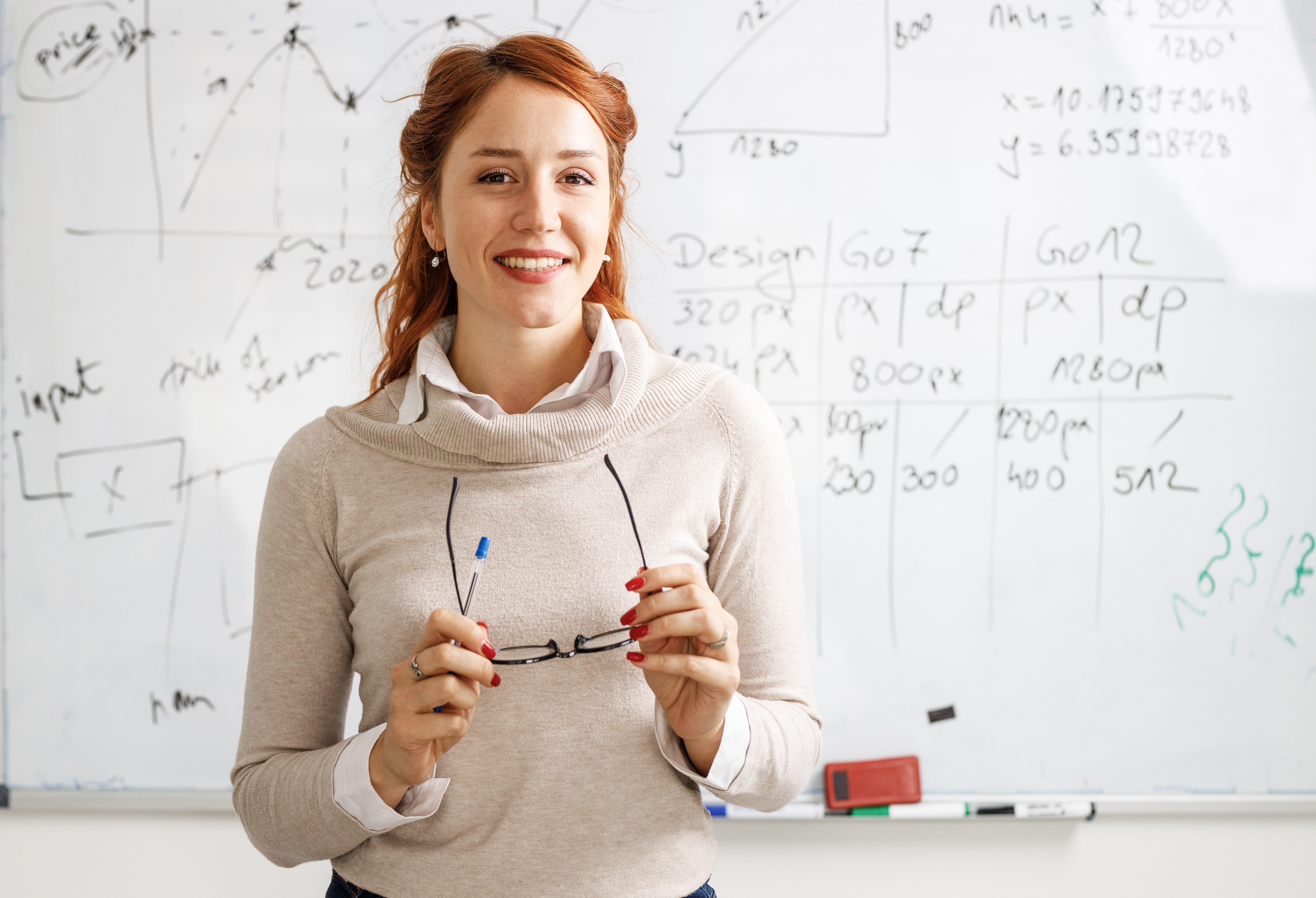 A woman standing in front of a whiteboard.