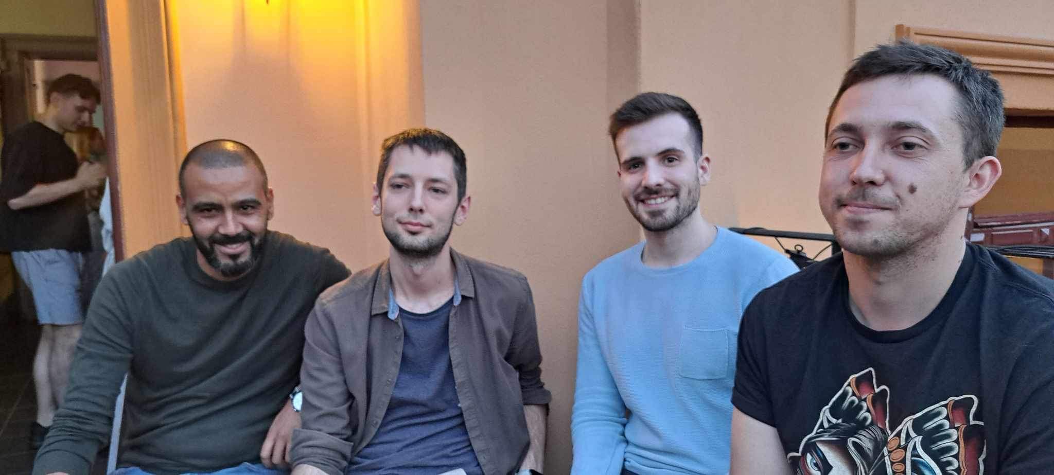 Four men sitting next to each other. 