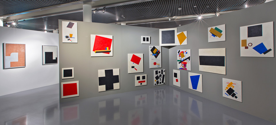Interior of the museum. Works of art hanging on a wall.