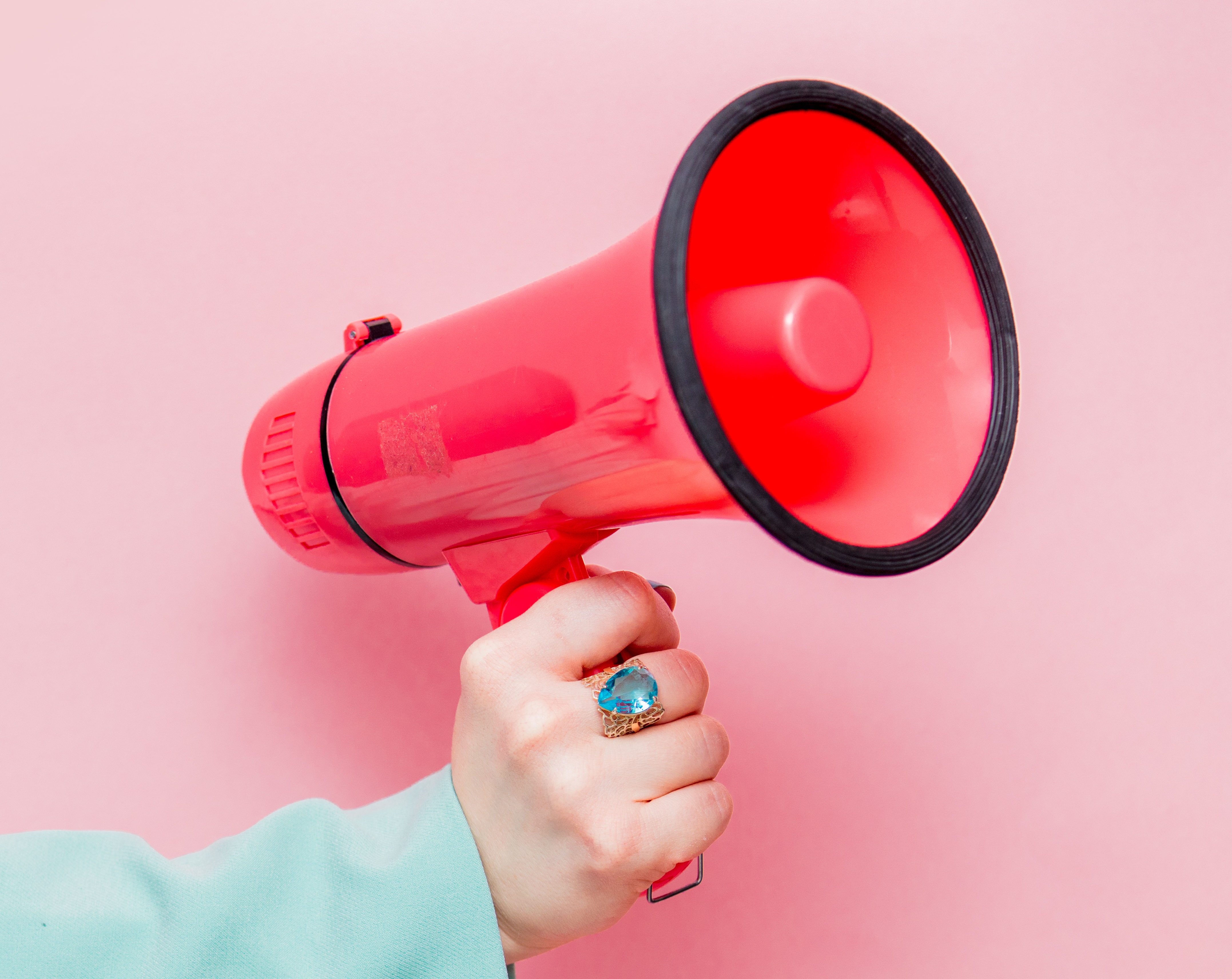 A hand holding a red megaphone.