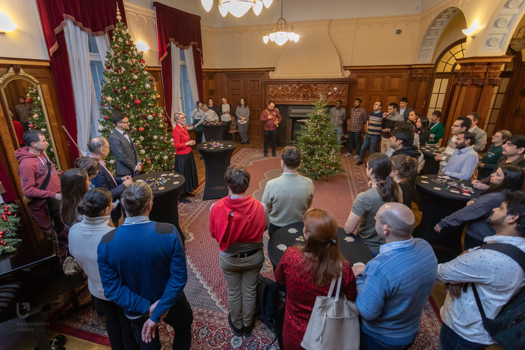 People standing in a circle around a Christmas Tree.
