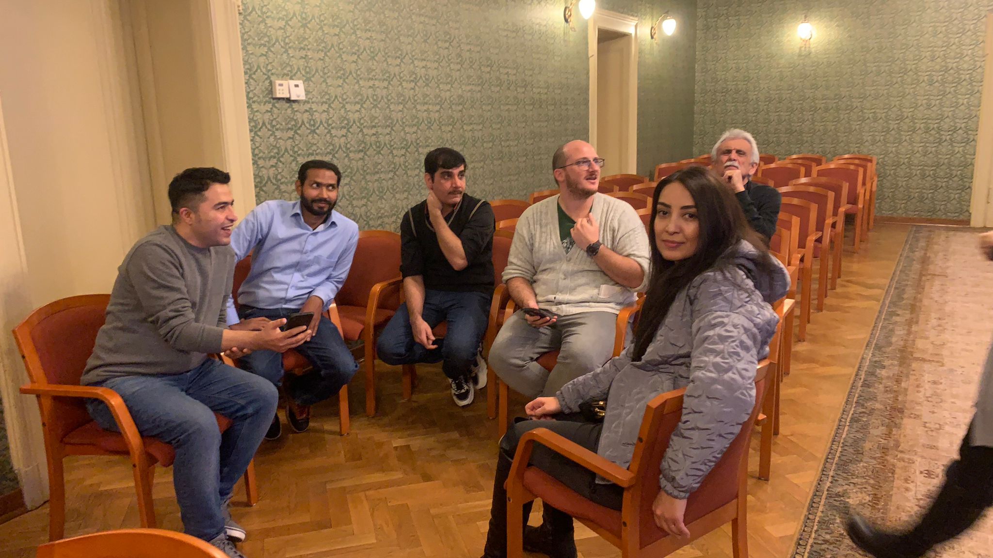 People sitting in a circle playing a game.