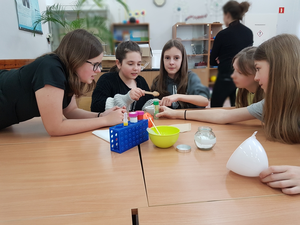Kilkoro dzieci siedzących przy stole pracujących w grupie