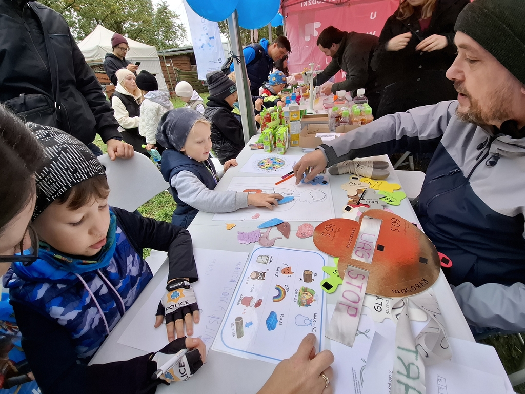 Dwoje dzieci przy stole rozwiązuje zagadki naukowe podczas pikniku