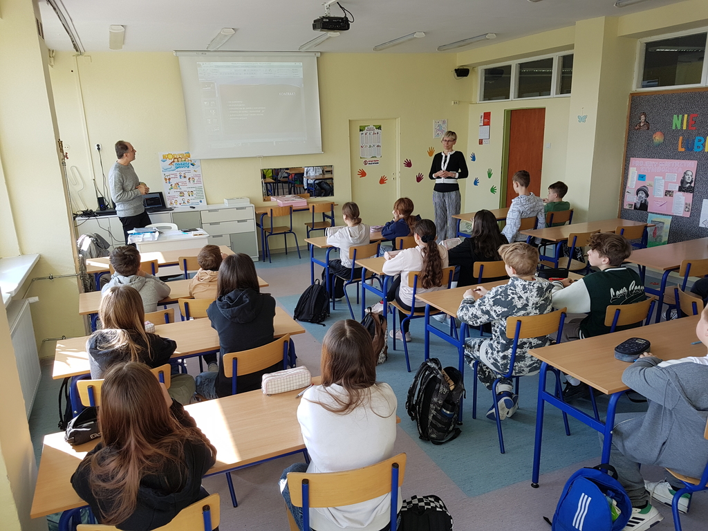 Dzieci w klasie w szkole słuchają wykładowcy
