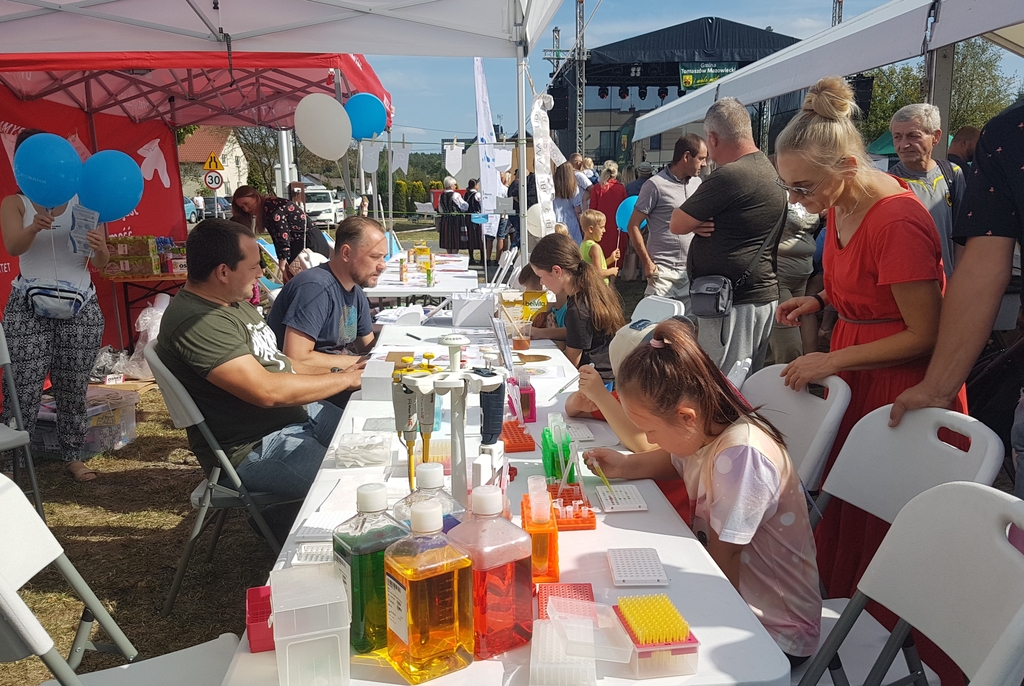 Stoisko naukowe uniwersytetu wraz z zainteresowanymi osobami