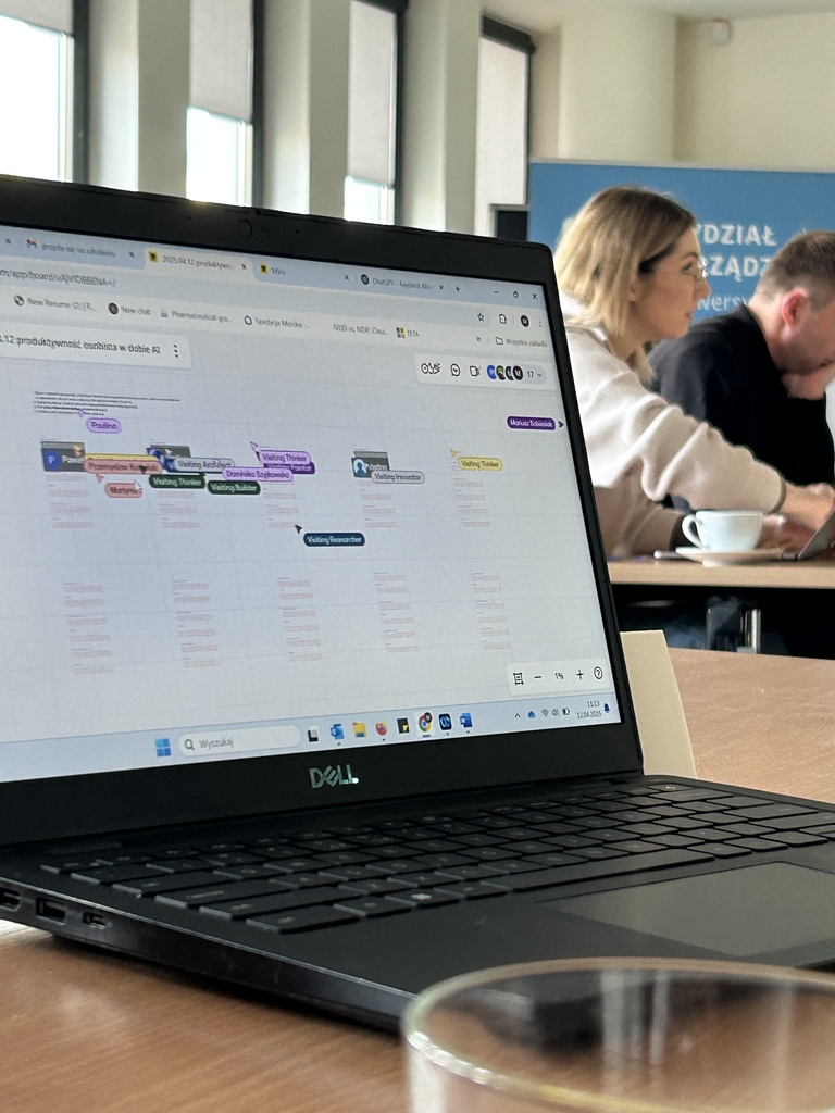 na pierwszym planie laptop, w tle osoby