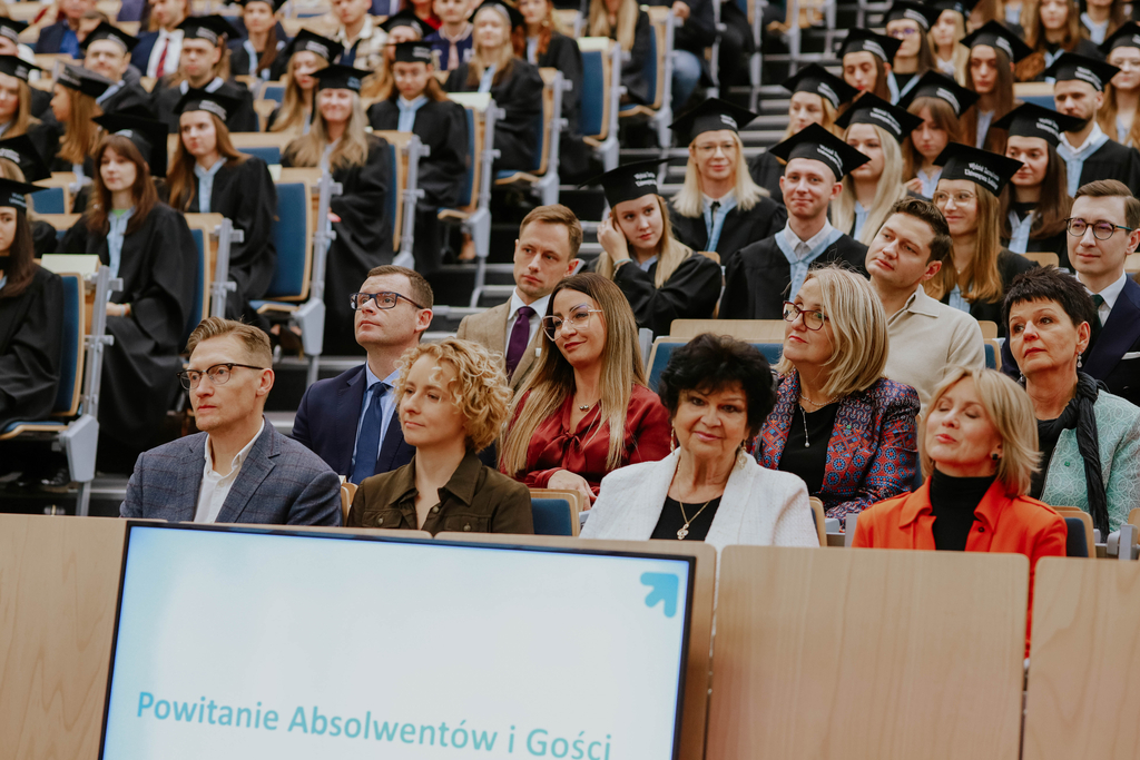 goście na auli, na drugim planie absolwenci
