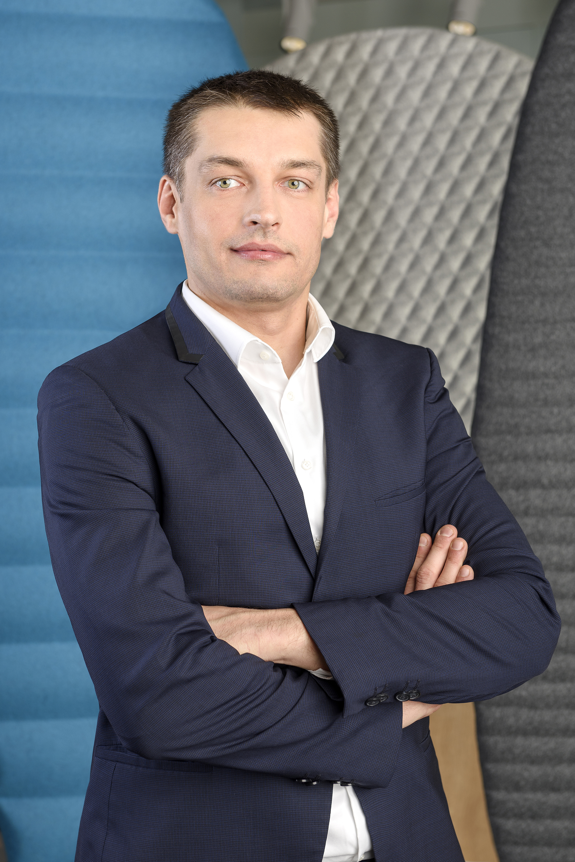 absolwent mężczyzna stoi z założonymi rękoma i spogląda w bok