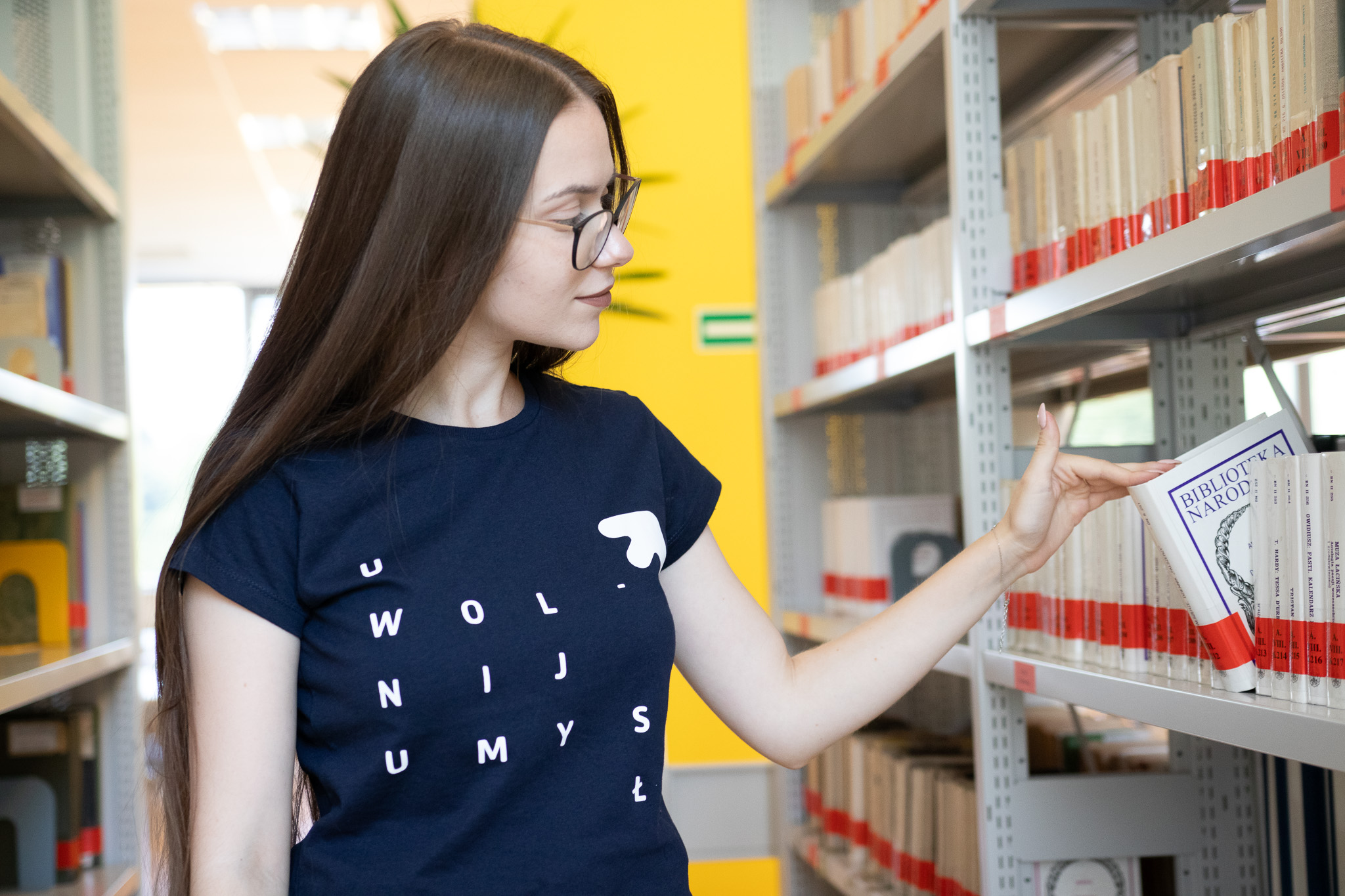 STudentka przeglądająca książki w bibliotece