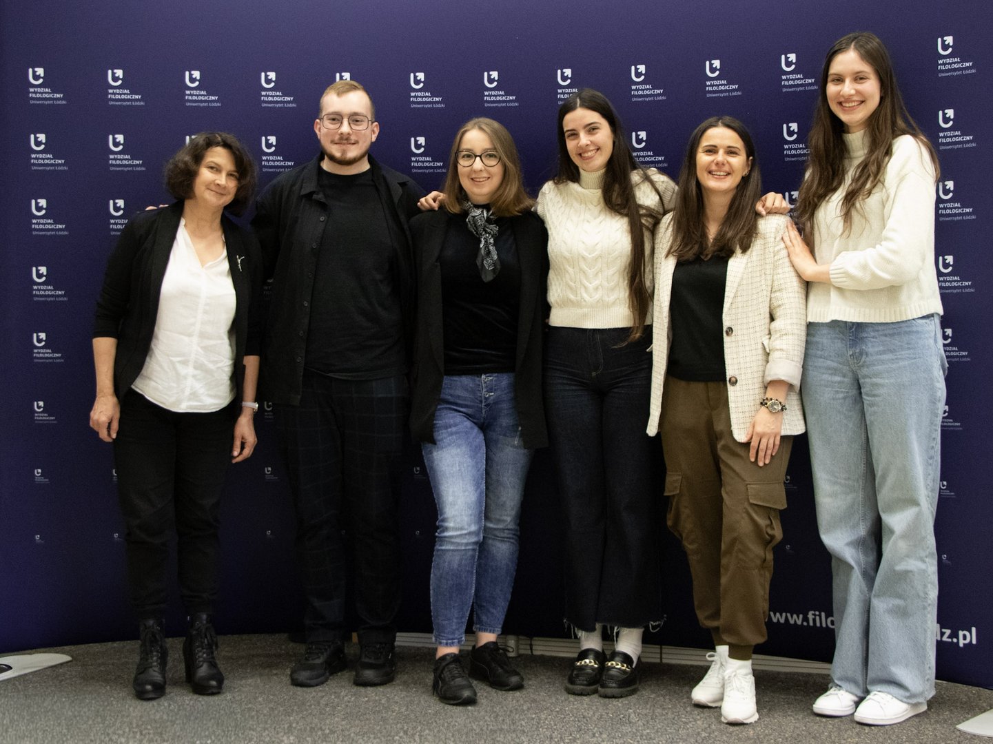 a photo of the entire project group in front of the faculty banner