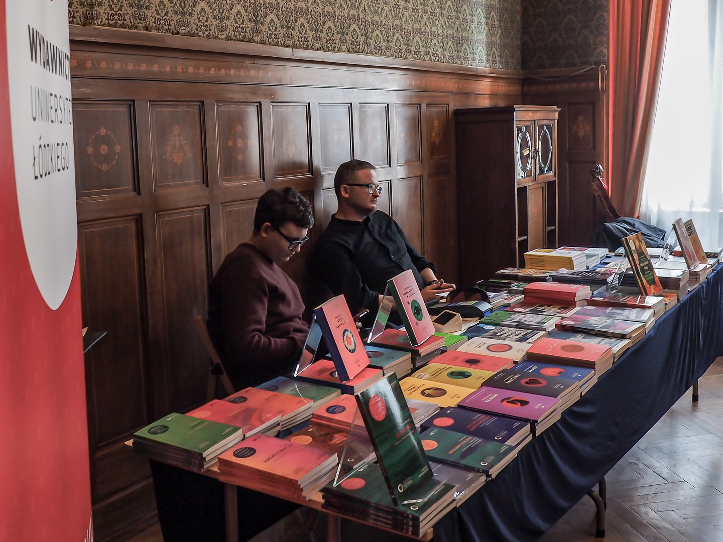 Organizatorzy konferencji za stołem z materiałami promocyjnymi