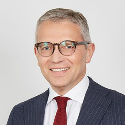 mężczyzna w garniturze i w okularach na jasnym tle