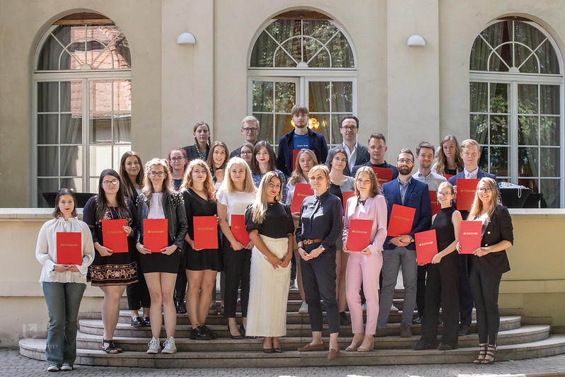 nagrodzone osoby studiujące trzymające dyplomy