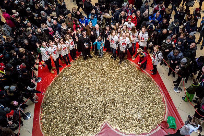  The University of Lodz students from the Student Science Club Inwestor standing with the University of Lodz authorities next to a heart made of gold coins