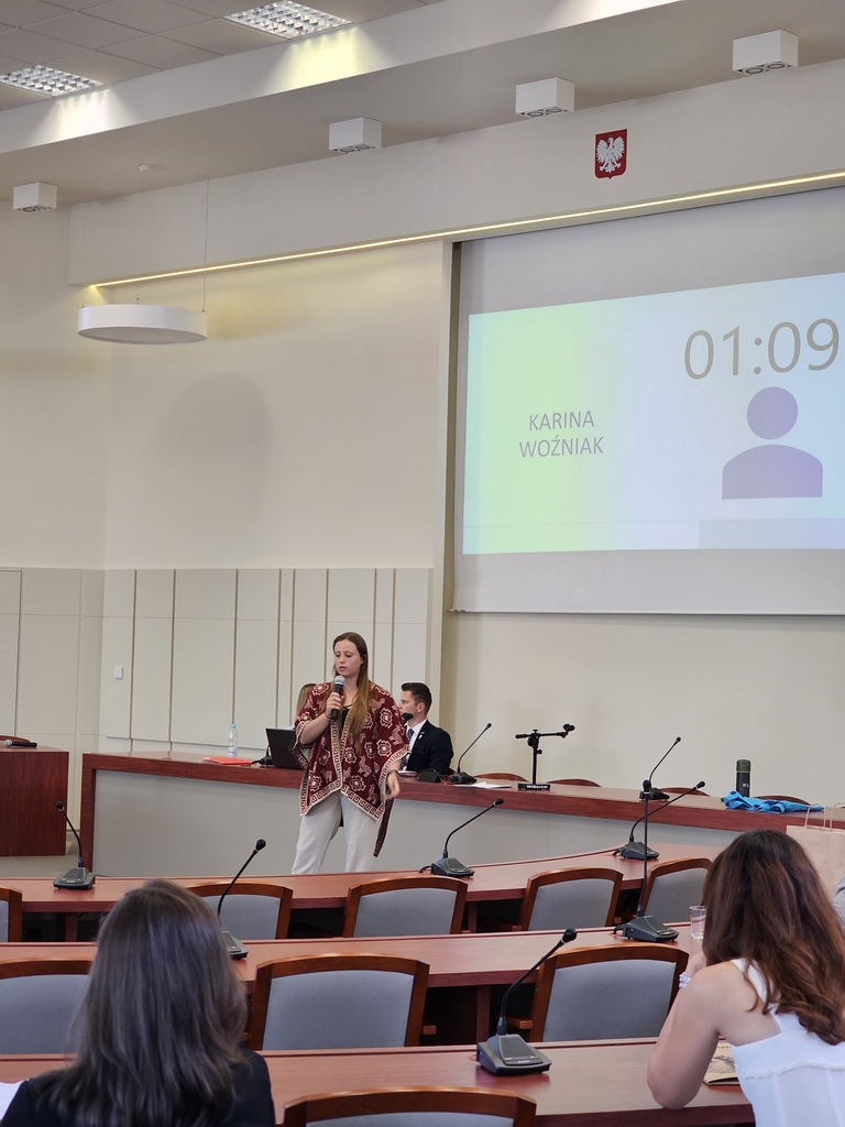 Karina Woźniak w sali wykładowej stoi przed publicznością