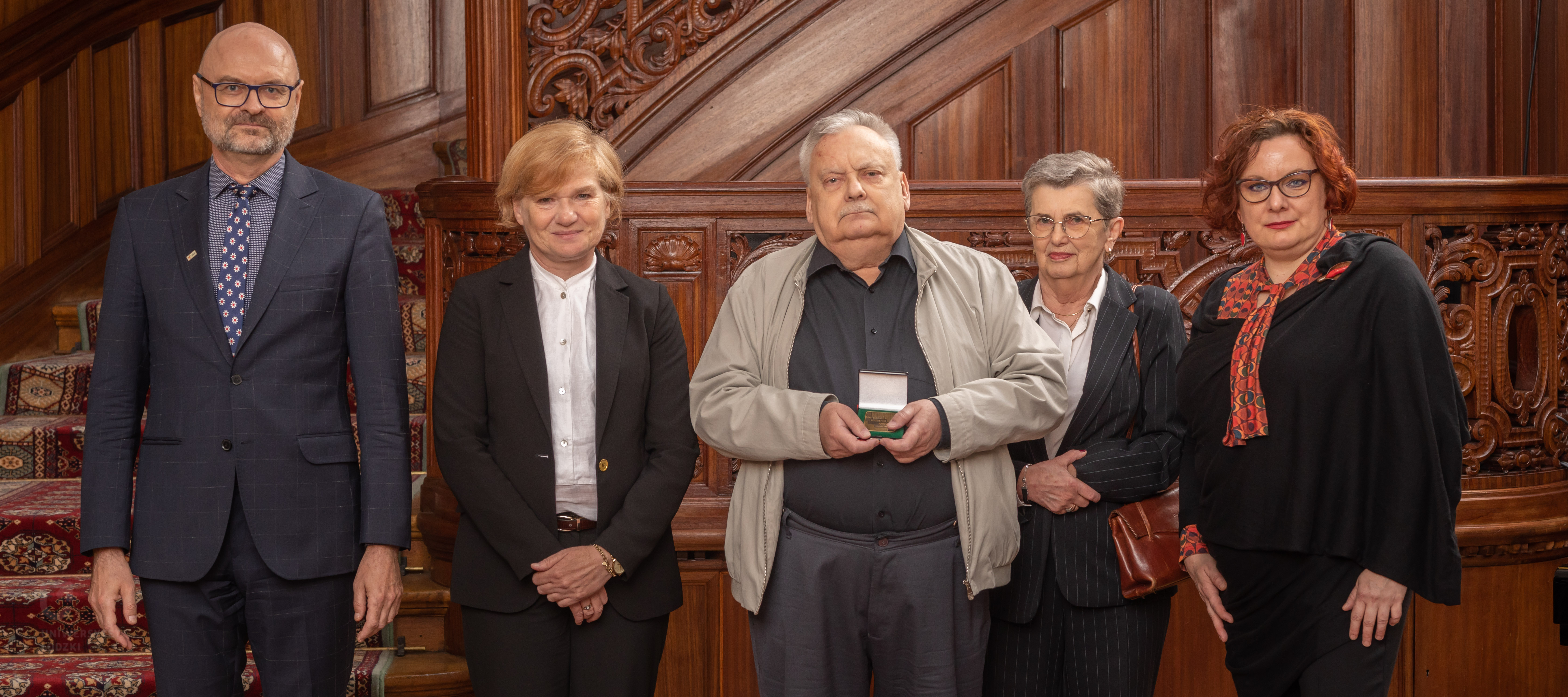 Andrzej Sapkowski i uczestnicy wydarzenia po wręczeniu medalu