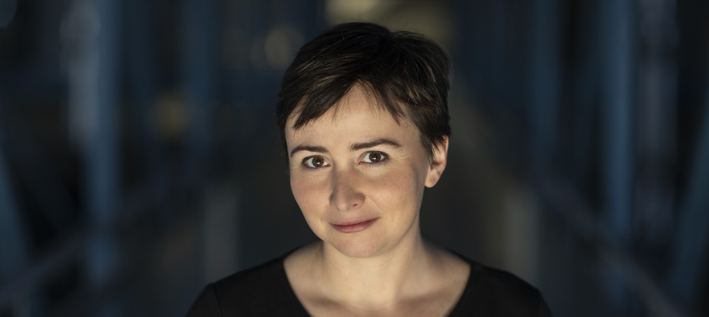 A portrait photo of Dr Agata Zysiak on a dark background (Photo: Dr Bartosz Kałużny)