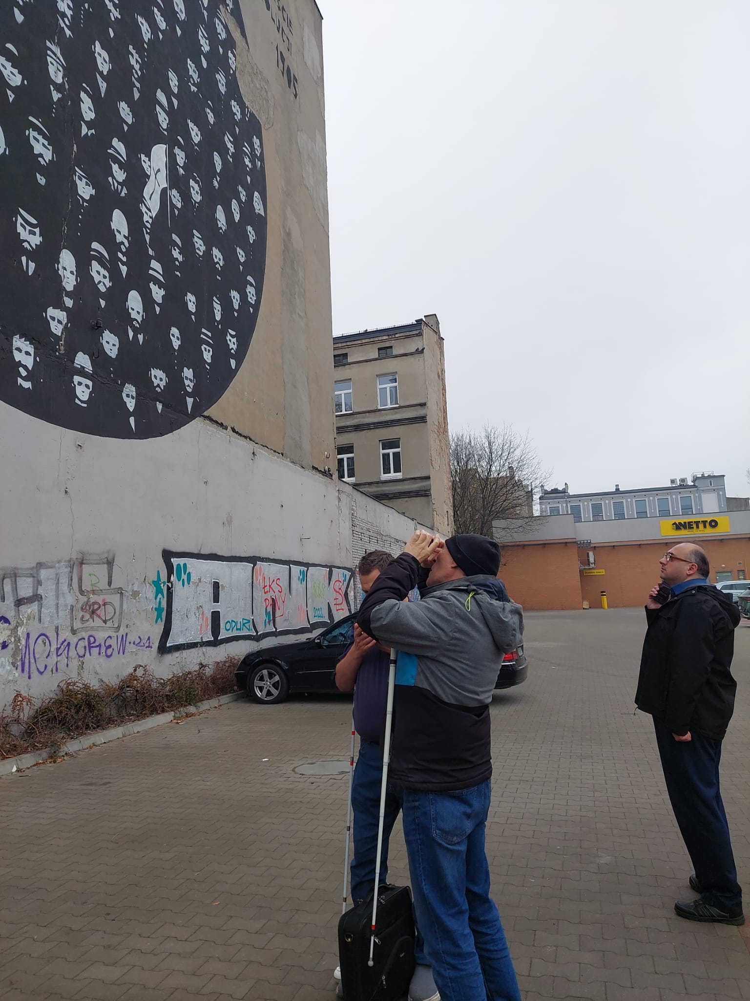 osoba niedowidząca oglądająca mural za pomocą telefonu