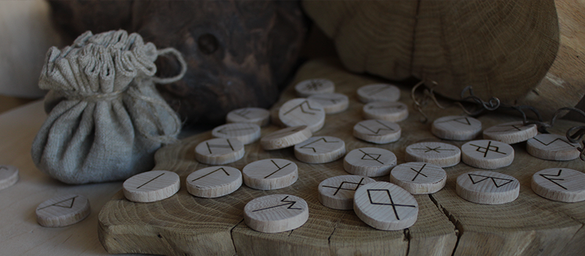 Worek, wokół którego leżą drewniane klocki z napisanymi znakami wikingów